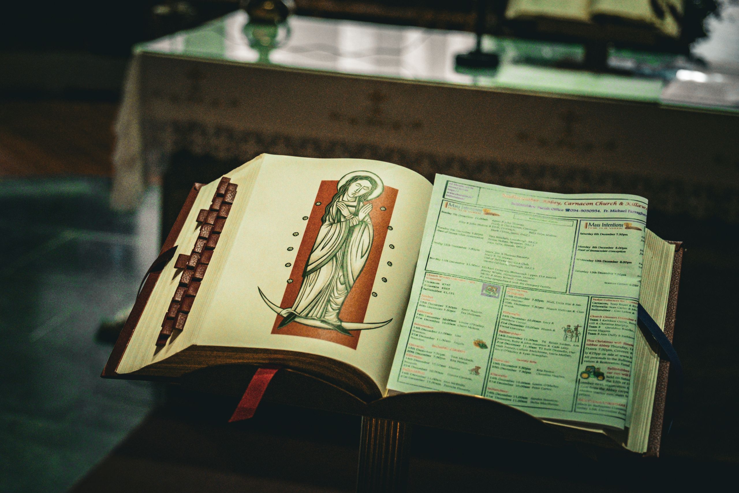 An open prayer book with religious imagery inside a church in Ireland, capturing spiritual essence.